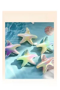 Macro detail of five gradient starfish hair claw clips on water ripples and sea shells
