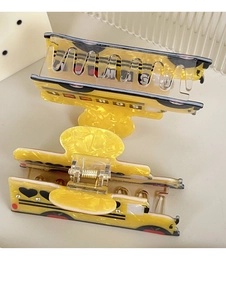 Close-up of yellow school bus hair claws made of acetate with marble texture and school text