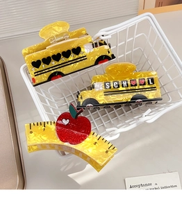 Detailed macro of school bus and ruler hair clips with apple design in mini basket