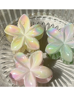 Macro detail of vibrant frangipani hair claws with iridescent pearlescent finish
