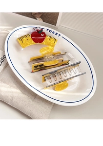 Close-up of cute ruler and school bus shaped hair claws on a stylish ceramic plate