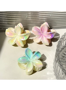 Detailed view of three iridescent plumeria hair claws with colorful gradient finishes