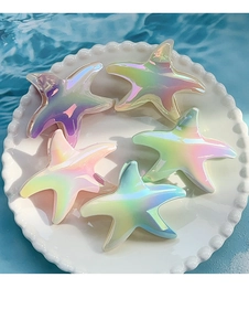 Detailed view of iridescent gradient starfish hair claws on a pearl decorative plate