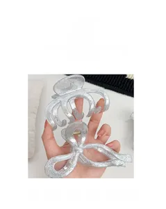 Detail of silver glitter hair claw and bow clip set with high-end sparkling texture
