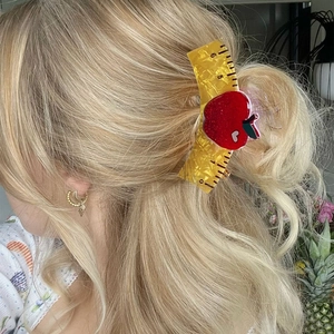 Playful ruler and red apple hair claw clip in a stylish side view hairstyle look