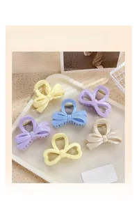 Détail des pinces à cheveux pastel en forme de nœud et de cœur dans un plateau