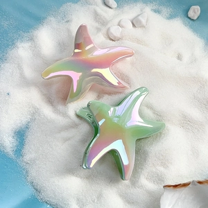 Starfish hair clips with gradient iridescent finish on a beach-themed background