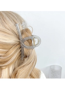 Sparkling silver glitter hair claw clip styling a low bun with elegant shimmer detail