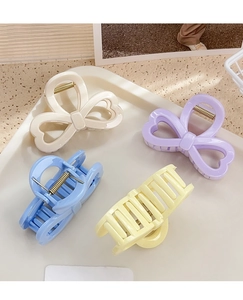 Détail de quatre pinces à cheveux pastel avec nœuds et formes rectangulaires