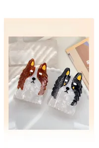 Détail des pinces à cheveux Border Collie en marron et noir sur une assiette en porcelaine