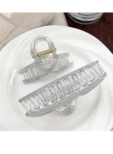 Detail view of silver glitter hair claws in large and small sizes on ceramic tray