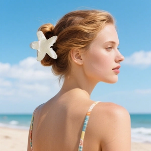 Starfish hair claw clip with pearlescent finish worn on hair at a sunny beach