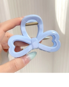 Détail de la pince à cheveux ruban en résine bleu clair avec ressort en métal doré