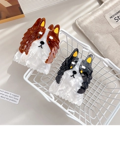 Détail de deux pinces à cheveux Border Collie en acétate dans un petit panier blanc