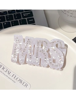 Détail des lettres MRS en strass sur une grande pince à cheveux effet marbre