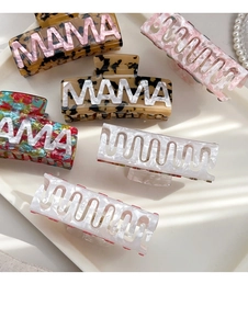 Detail of MAMA lettering claw clips and colorful floral hair accessories in a soft layout