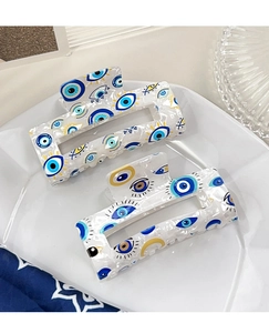 Detail von quadratischen Acetat-Haarklammern mit blauen Evil Eye-Mustern auf Perlweiß
