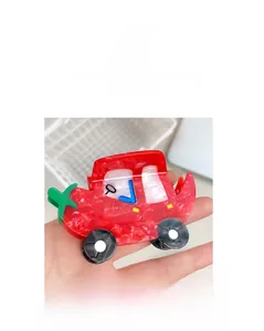 Detailansicht einer kreativen roten Haarspange in Autoform aus strukturiertem Acetatmaterial