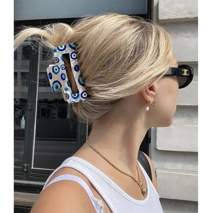 Blauer Evil Eye Haarklammer aus Acetat für Damen in einer stilvollen Outdoor-Haarstyling-Pose