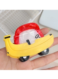 Detailansicht einer kreativen Haarspange in Autoform aus rotem und gelbem Acrylmaterial