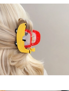Detailansicht einer kreativen Bananen-Haarklammer in hellem Haar für einen sommerlichen Look