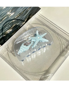 Détail macro d'une pince à cheveux océan avec décorations étoile de mer et coquillage