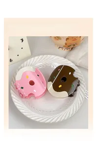 Detailed view of pink and brown donut hair claw clips with colorful sprinkles on a tray