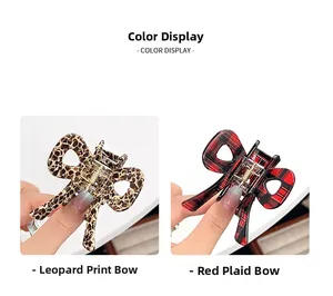 Detail shot of leopard print and red plaid bow hair claws held by hand for display