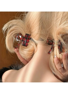 Detail of red checkered bow hair clips styled on blonde braided hair for back view