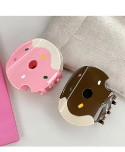 Close-up of donut-shaped acetate hair claws with colorful sprinkles and bite-mark detail