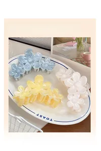 Detailed view of floral hair claws with marble texture in blue, yellow, and cream white