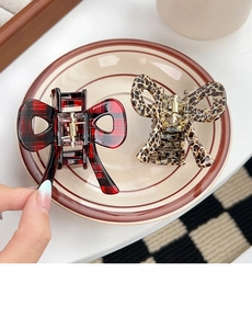 Detail of red plaid and leopard print bow hair claws made of glossy acetate resin