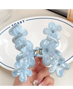 Detail of light blue marble flower hair claw clip with strong spring in hand