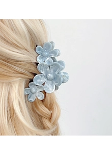 Detailed view of floral hair claw clip with blue marble pattern on braided blonde hair