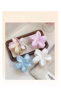 Detailed set of four floral acetate hair claws in pastel colors on an aesthetic background