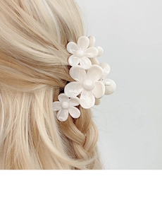 Detail showing creamy floral hair claw clip with pearl finish on blonde hair