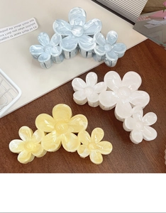 Detail of floral hair claws in blue white and yellow with elegant marble texture