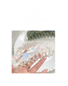 Detail view of large iridescent pearl hair claw clip with cutout design for bun styles