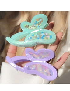 Detailed close-up of butterfly hair claw clips in mint green and lavender purple