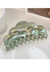 Macro detail of the green marbled hair claw clip on a white ceramic tray setup