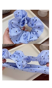 Detail of blue striped heart scrunchie showing high elasticity and soft cotton texture