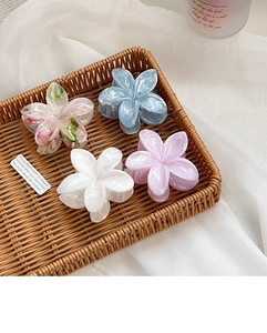Detailed macro view of acetate floral hair claws with elegant marble textures in a tray