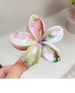 Close-up of large floral hair claw clip featuring pink and green marble texture finish