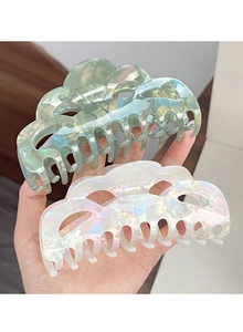 Close-up of wavy mint green and iridescent white acetate hair claw clips for thick hair