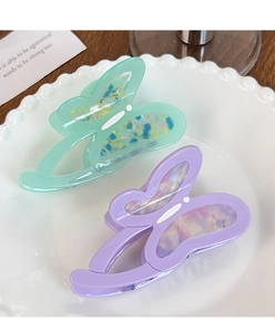 Detail of mint green and lavender butterfly hair claws with iridescent shell textures
