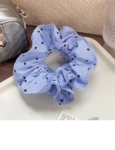 Close-up of blue striped scrunchie with heart patterns on a white display tray