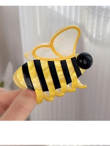 Détail d'une pince à cheveux en forme d'abeille avec texture en résine à rayures