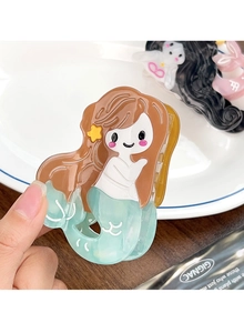 Detail view of cartoon mermaid hair claw clip in translucent blue acetate held by hand