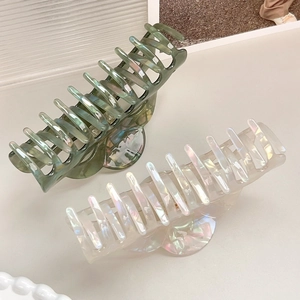 Elegant oversized pearlescent hair claw clips in dark green and cream white colors