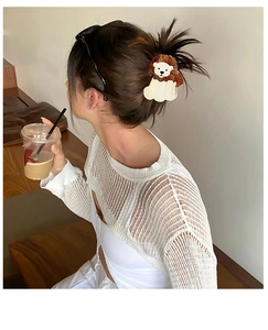 Detail view of cartoon lion hair claw clip worn on a woman's half-up hairstyle